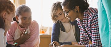Adult teaching a group of students in a classroom.