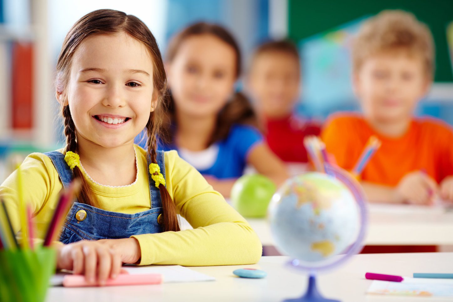 Preschool children smiling in a classroom.